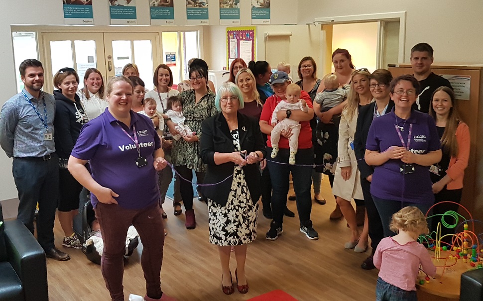 Baby clinic launch with group of parents, volunteers, staff and babies - providing health advice